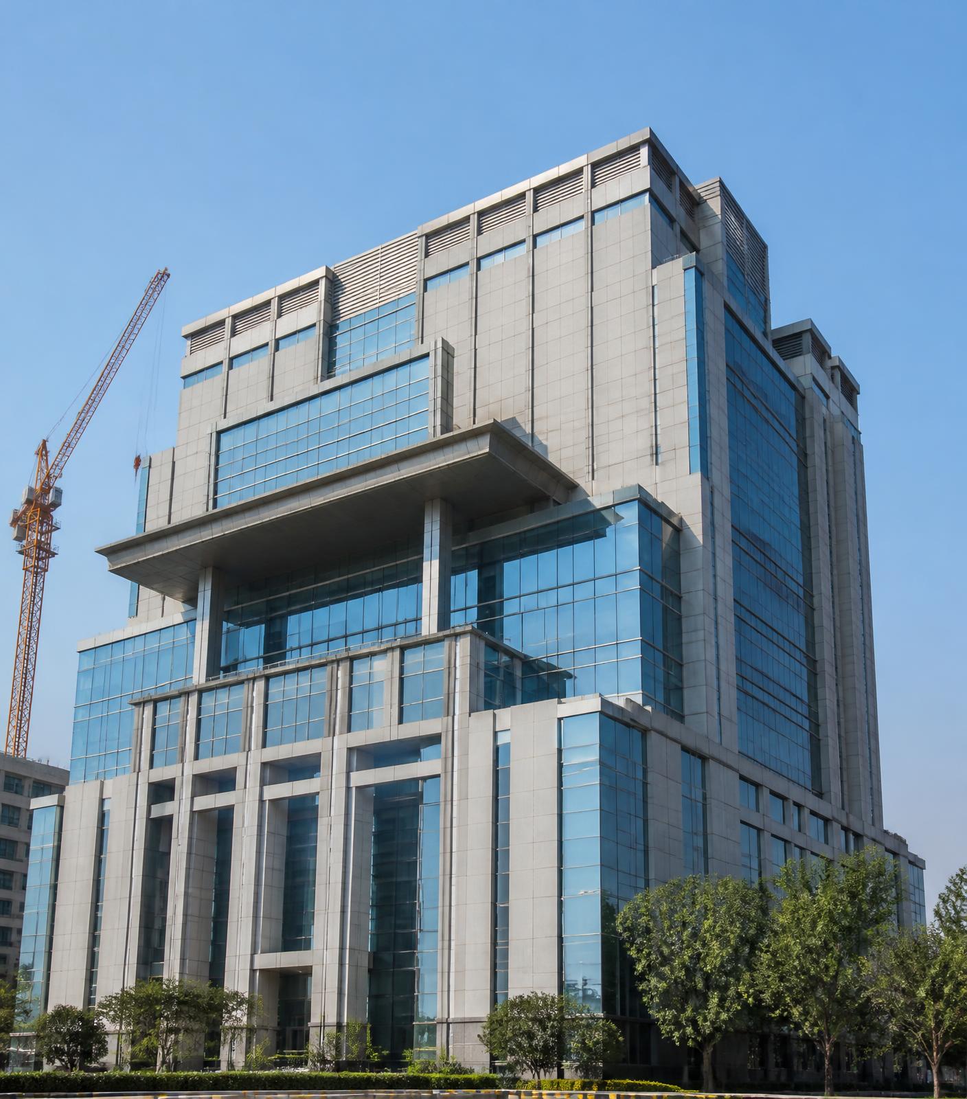 Completed modern multi-storey commercial building with construction crane